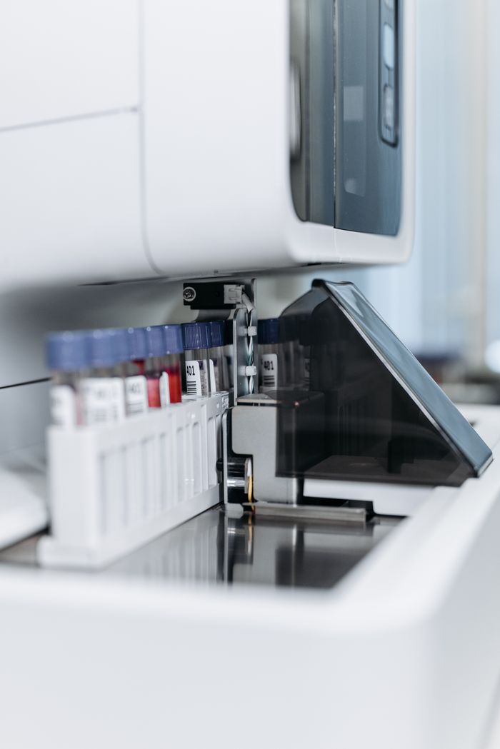 Services Close-up of an automated laboratory machine handling test tubes for research.