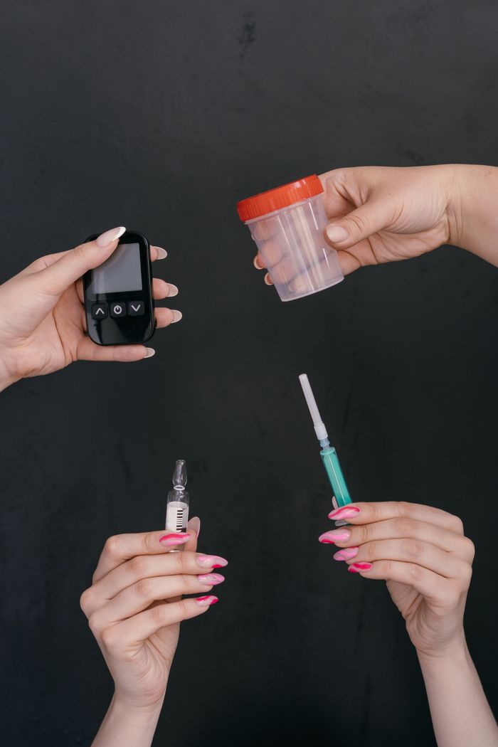 Services Hands displaying diabetes management tools including a glucometer, insulin syringe, and container.